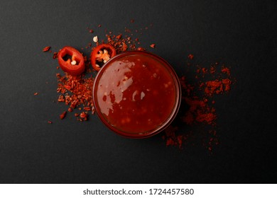 Chilli Pepper And Bowl Of Sauce On Black Background, Top View