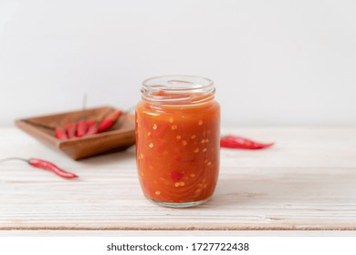 Chilli Or Chilli Sauce In Bottle And Jar On Wwod Background