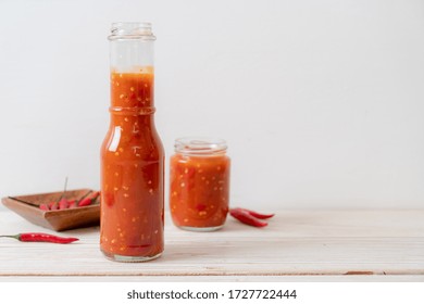 Chilli Or Chilli Sauce In Bottle And Jar On Wwod Background