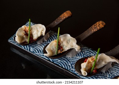 Chilli Sauce Dumpling With Spoon Serves In The Fine Dining Japanese Restaurant In A Fine Rectangle Serve Plate Board, In Black Scene Background