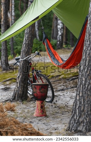 chilling setup with hammock in forest, bicycle and small African hand drum