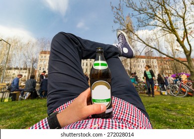 Chilling/relaxation concept. Young man in the park with bottle of lager beer - Powered by Shutterstock