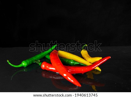 Chilly pepper on the black background. mix peppery, yellow,green, Red