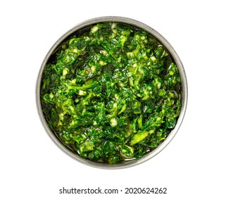 Chimichurri verde in a bowl isolated on a white background. Chimichurri - Latin American sauce made from various herbs, garlic and pepper. Sauce of parsley, oregano, rosemary, garlic, pepper, and oil