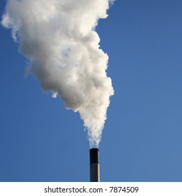 Chimney Billowing White Smoke Into Blue Sky