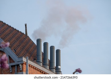 Chimney On The Flat Roof Off A Big Building In The City With A Thick Plume Of Smoke