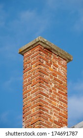 Chimney of red bricks and a blue sky.