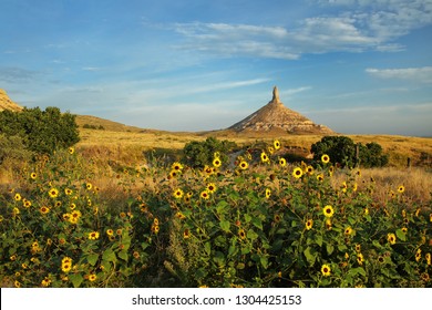 Chimney Rock National Historic Site with sunflowers, western Nebraska, USA. The peak of Chimney Rock is 1289 meters above sea level.
