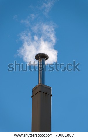 chimney with smoke out the sunlit