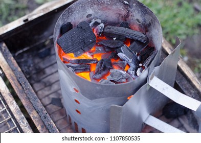 A chimney starter in use to get the charcoal ready for the grill in a more environmentally friendly way. - Powered by Shutterstock