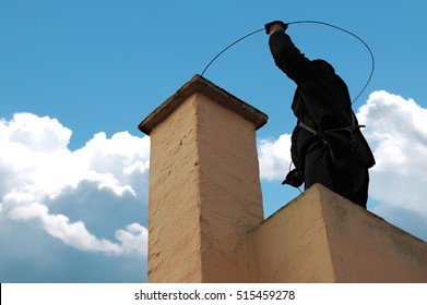 Chimney sweeper on the roof of a house in an attempt of chimney sweeping