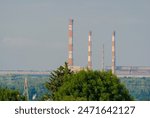 Chimneys of the steelworks in Ostrowiec Swietokrzyski among the forests. A thriving industrial plant on a valley slope among lush forests. 