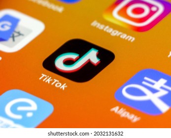 China - 22nd August 2021: Close-up Of Tik Tok Application Icon On IPhone Smartphone Screen, Other Apps (Alipay, Instagram Etc) Out Of Focus On Orange Gradient Background Wallpaper