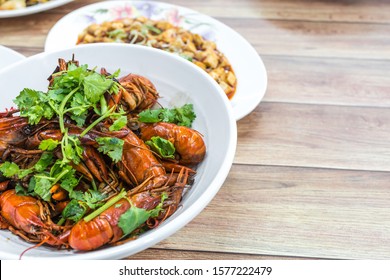 China, Chongqing Sichuan Spicy Dried Chilli Small Lobsters, Among Other Dishes In The Background. Food Photography At Chinese Restaurant.