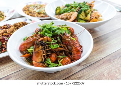 China, Chongqing Sichuan Spicy Dried Chilli Small Lobsters, Among Other Dishes In The Background. Food Photography At Chinese Restaurant.