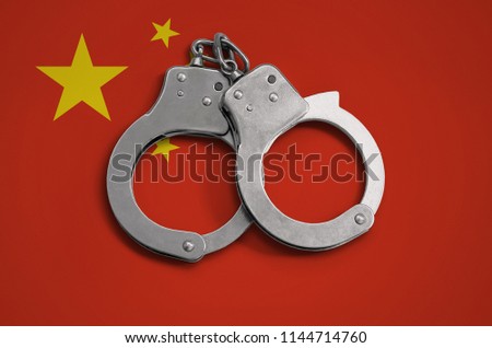 China flag  and police handcuffs. The concept of observance of the law in the country and protection from crime