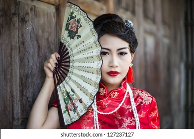 China Girl,Chinese Woman Red Dress Traditional Cheongsam ,close Up Portrait With Old Wood Door