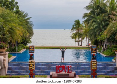 China, Hainan Island, Sanya bay - January 3, 2019. Celebration of St. Valentine's Day on the tropical islands. Inscription love on the background of exotic palms .a tourist who enjoys a view
