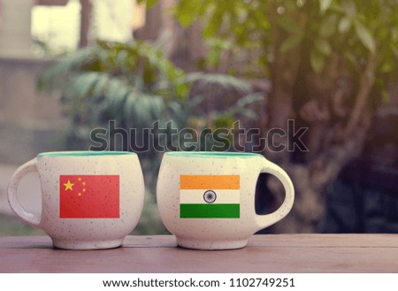 China and India Flag on two tea cups with blurry background