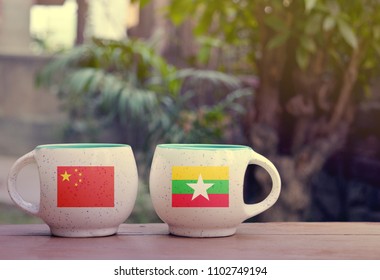 China And Myanmar Flag On Two Tea Cups With Blurry Background