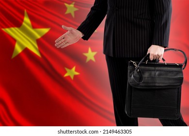 China Politician On Background Of Chinese Flag. Portrait Of China Politician Without Face. He Makes Hand Gesture. Concept Member Of Chinese Communist Party. Negotiations With China Communist Party.