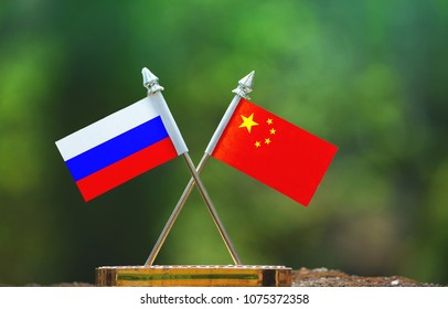 China And Russia Small Flag With Blur Green Background