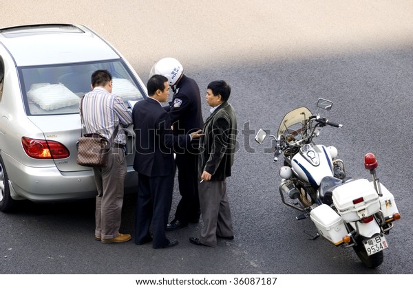 CHINA, SHENZHEN - DECEMBER 9: Policeman resolving\
car accident, even there are more and more cars in China, driving\
skills are getting worse. The accident  occured on December 9, 2008\
in Shenzhen, China.