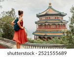 China Travel. Woman traveler relaxing enjoying travelling looking at nature view from old Chinese temple, tourist attraction in Beijing, china. Summer palace tourism destination, Asia travel