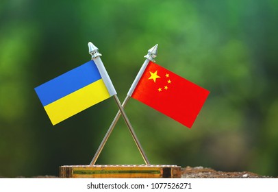 China And Ukraine Small Flag With Blur Green Background