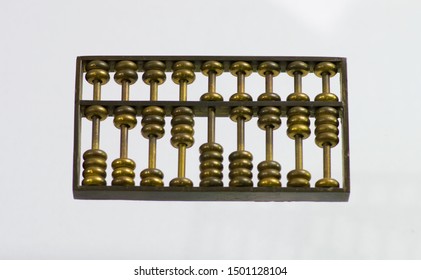 Chinese Abacus Ancient Antique Counting Machine In Bronze Metal Set In Nine Figures From One To Nine. Chinese Abascus Hand Mechanical Calculating Machine. Close Up Isolated On Light Background.  