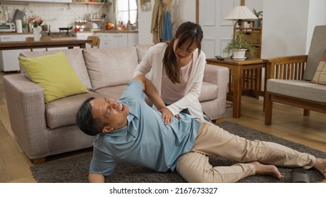 Chinese Adult Daughter Running Into Living Room To Help Her Retired Dad And Calling Ambulance With Smartphone. Elder Senior Person Slip And Fall Risk At Home Concept