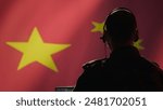 Chinese army military dispatcher looking at surveillance transmission on laptop, relaying informations for troops using headset, isolated over fluttering China flag background, camera B