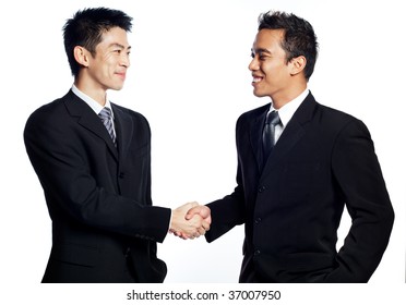 A Chinese, Asian Businessman Shaking Hands And Smiling With An African Business Associate. Signifies The Closing Of Deals. Shot In Studio Isolated On White