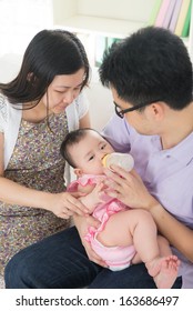 Chinese Asian Parents Feeding Baby Boy At Home