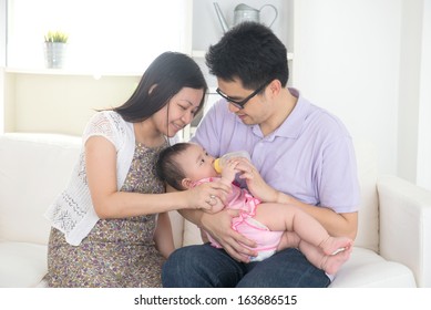 Chinese Asian Parents Feeding Baby Boy At Home