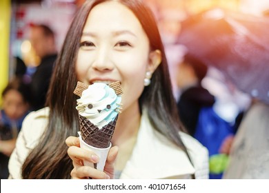 Chinese Asian Young Female Model Eating Ice Cream Cone On Hong Kong Street