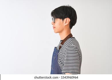 Chinese Bartender Man Wearing Apron And Glasses Standing Over Isolated White Background Looking To Side, Relax Profile Pose With Natural Face With Confident Smile.