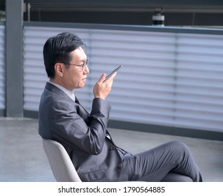 Chinese Businessman Using Cellphone To Leave Voice Message. Copy Space.