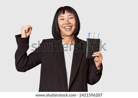 Chinese businesswoman holding airplane tickets in studio