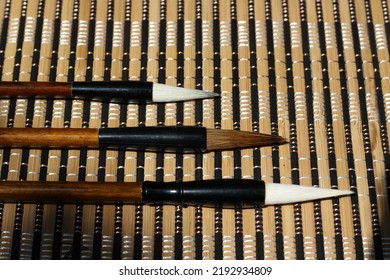 chinese calligraphy brush wide spacing with shadow, horizontal background.Chinese calligraphy brush collection. Mao bi 《毛笔》means brush in chinese. Chinese calligraphy brush is used to do shu fa 《书法》. 