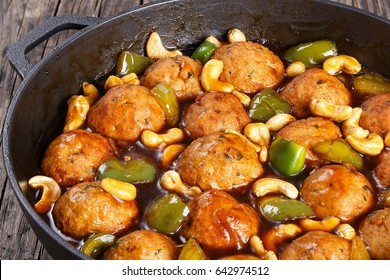 Chinese Cashew Chicken Meatballs Tossed With Sauce Of Green Bell Pepper Chunks, Onion, Soy Sauce, Chinese Cooking Wine And Spices In Pan, Close-up