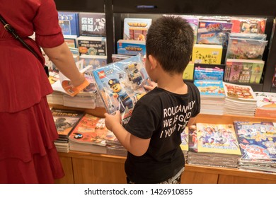 Chinese Child Reading A Lego Children Story Book In A Wired Bookstore With High Speed Broadband Internet With Wooden Shelves, Shanghai, China, Bricknetwork and brickcentral is Brick Creative Toy legos