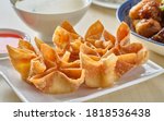 chinese crab rangoon fried wontons on plate with red sauce