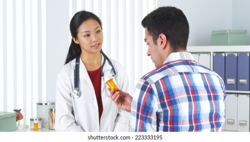 Chinese Doctor Prescribing Medication To Patient