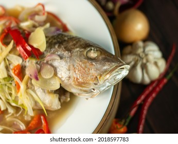 Chinese (east Asian) Steamed Fish Cooked With Herbs And Gingers Served On A White Ceramic Plate.