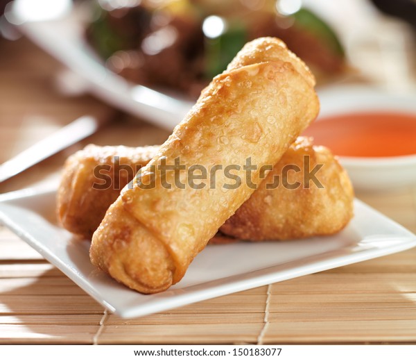chinese egg rolls with\
sauce on plate
