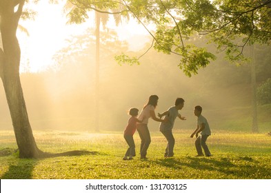 Chinese Family Having Quality Time Playing At Outdoor Park