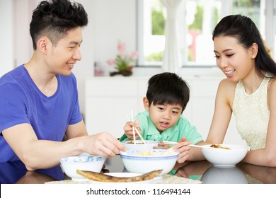 Chinese Family Sitting At Home Eating A Meal