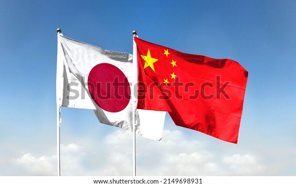 Chinese flag and Japanese flag with blue sky. waving\
blue sky