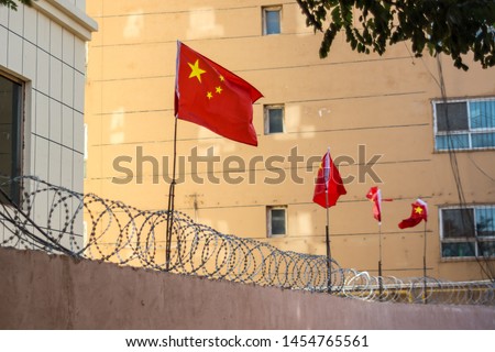 Chinese flags on barbed wire wall in Kashgar (Kashi), Xinjiang, China.